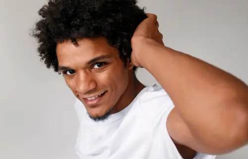 African man smiling and proud of thick hair on his head